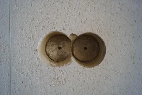 Old electric socket on a white wall, close-up of photo Stock Photos