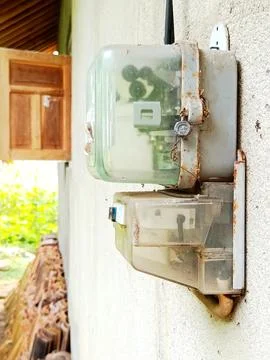 Old electrical meter box mounted on a wall, showing rusted metal parts Stock Photos