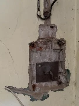 Old electrical panel area in a crumbling plaster wall Stock Photos