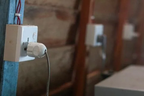 Old Electrical Socket With Plug on Rustic Blue Wooden Post in Traditional Bu Stock Photos