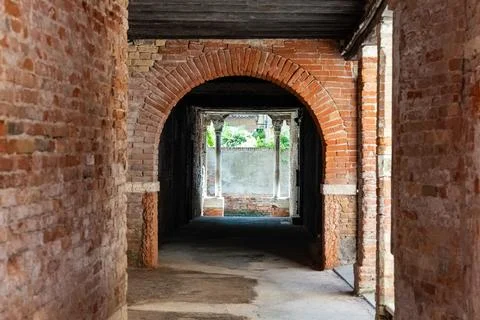 Old, empty arched hall or passage made of bricks with wooden beams in Venice Stock Photos