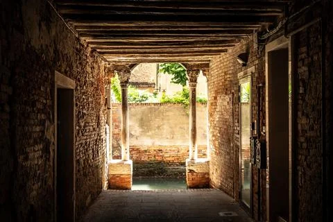 Old, empty arched hall or passage made of bricks with wooden beams in Venice Stock Photos