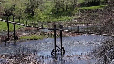 Old Empty Metal Pedestrian Bridge Across Small River At Countryside On Sunny Day Stock Footage 107126267