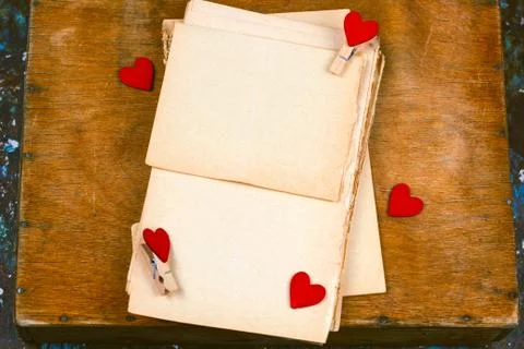 Old empty paper sheets and cloth pins with hearts  top view wooden table mock Stock Photos