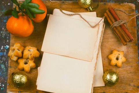 Old empty paper sheets,cinnamon , star shape cookies  and tangerines  top vie Stock Photos