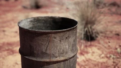 Old empty rusted barrel on sand Illustration