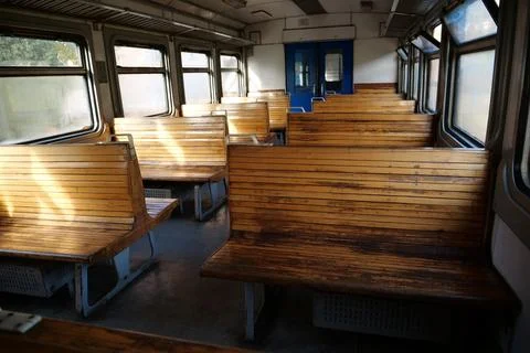 Old empty wagon of train. Wooden seats in an empty coach of train Stockfoto's