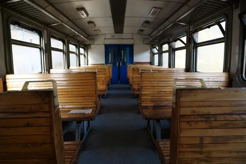 Old empty wagon of train. Wooden seats in an empty coach of train Stockfoto's