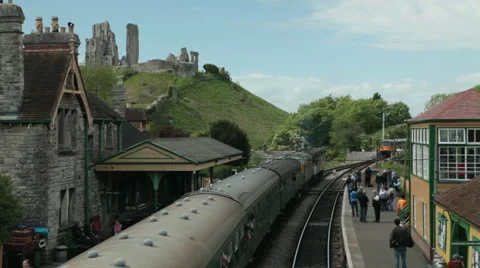 Old English diesel train pulling into station with castle in background Stock Footage 5091056