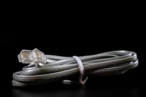 Old entangled cables, electronics and old cable connectors on a black table. Stock Photos