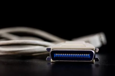 Old entangled cables, electronics and old cable connectors on a black table. Stock Photos