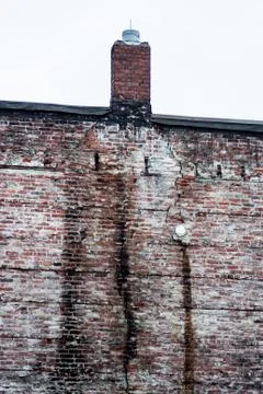 Old eroded brick wall and chimney Stock Photos