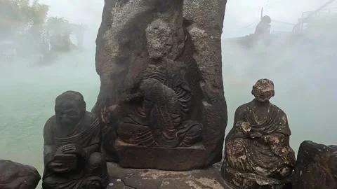 Old eroded statues in front of a geothermal hot spring in Japan. Buddha Video stock 249651569