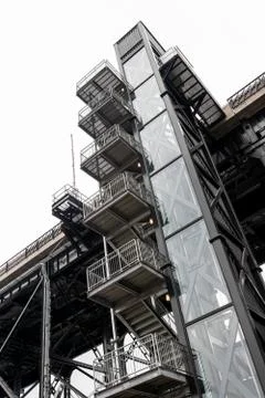 Old external elevator and steel stairway Stock Photos