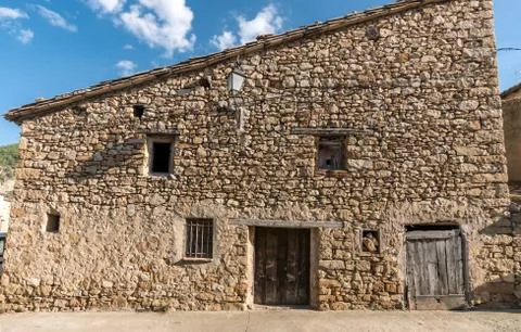 Old facade with stone cladding house in a village in spain Stock Photos
