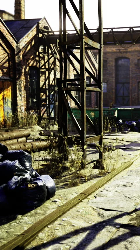 Old factory area with piles of garbage and weeds in sunlight Stock Footage 335299667