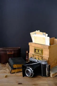 Old family photos 50s, 40s, retro camera, books on wooden table, concept of g Stock Photos