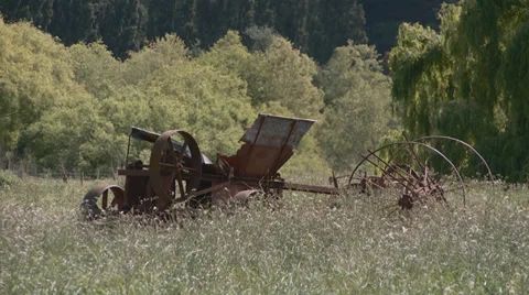 Old farm machine rusts in long grass Stock Footage 32325955