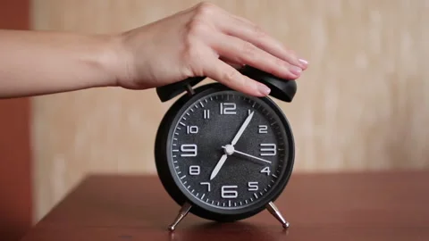 Old fashioned alarm clock ringing early in the morning. The woman's hand stops Stock Footage 257429599