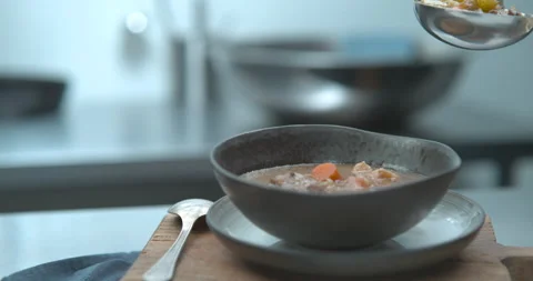 Old fashioned beef stew being ladled into ceramic bowl closeup in ultra slow mot Stock Footage 199459155