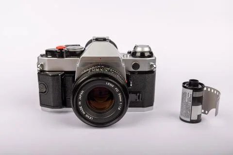 Old-fashioned camera aligned at the center of a white surface, accompanied .. Stock Photos
