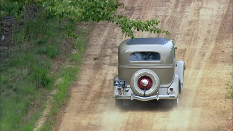 Old fashioned car driving through the dirt track in the forest Stock Footage 109122863