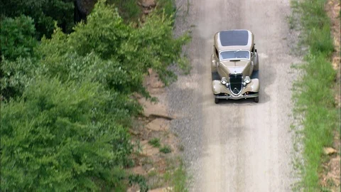 Old fashioned car driving through the dirt track in the forest Stock Footage 109122902