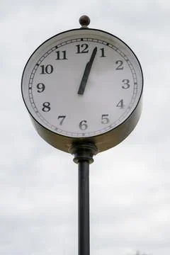 Old-fashioned clock mounted on a pole Stock Photos