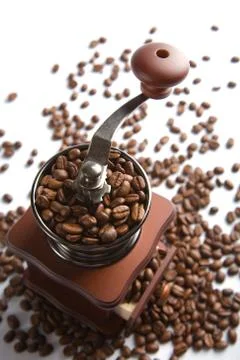 Old-fashioned coffee grinder and roasted coffee beans isolated Stock Photos