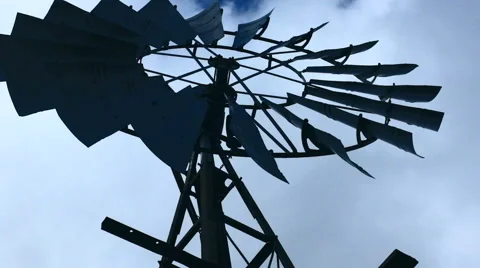 Old-fashioned farm windmill turning to pump up water Stock Footage 54423417