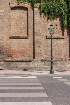 Old fashioned lamp post in front of old brick building, with bricked up windows Stock Photos