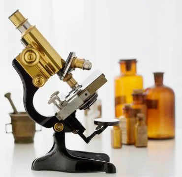 Old fashioned microscope and bottles Stock Photos