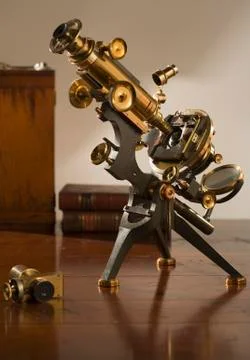 Old fashioned microscope on table Stock Photos