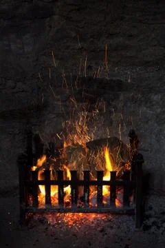 Old fashioned open log fireplace in with flames Stock Photos