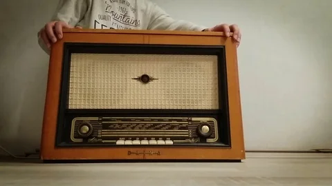 Old-fashioned player. Young man opens and closes radio gramophone. Stock Footage 70763606