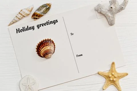 Old fashioned postcard and shells on the wooden deck Stock Photos