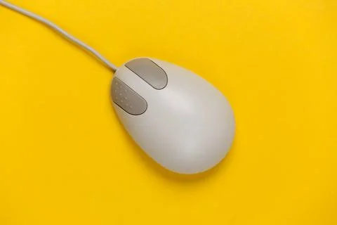 Old-fashioned retro pc mouse on a yellow background. Top view Stock Photos