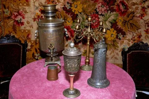 An old-fashioned set table. copper dishes, candle holder. Stock Photos
