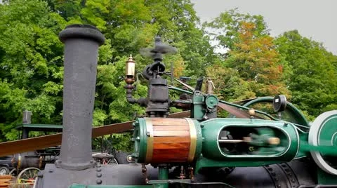 An old-fashioned steam engine tractor creates power to drive a pony saw mill. Stock Footage 12157175