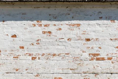 Old fashioned surface of wall with bricks and white stucco Stock Photos