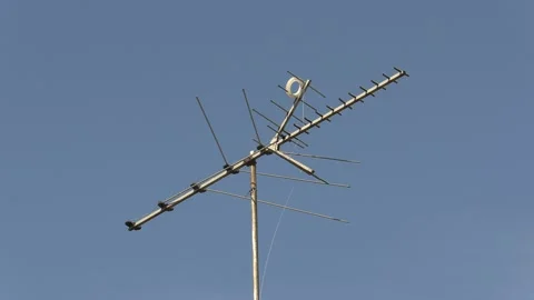 Old fashioned TV antenna on house roof for television signals reception Stock Footage 152007286