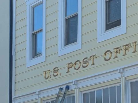 Old-fashioned yellow U.S. Post Office building with gold lettering Stock Photos