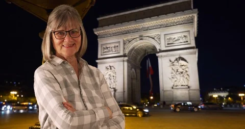 Old female looking content crossing arms posing by Arc de Triomphe in Paris Stock Footage 86498839