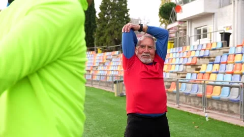 Old fiends warming up in a running track in winter Stock Footage 258218539