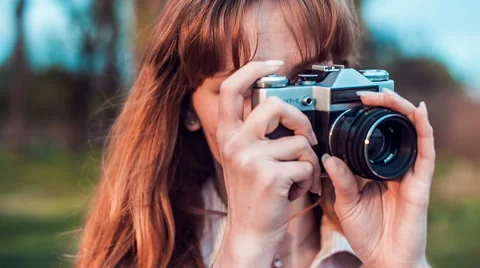 Old film camera transforms into a smartphone, when girl takes pictures. Stock Footage 62857858