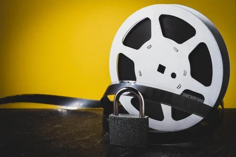 Of vintage film reel and strips hangs on a brick wall. 35 mm film