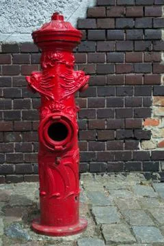 Old fire hydrant against the brick wall Stock Photos