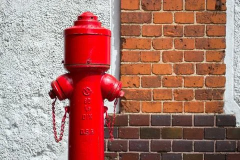 Old fire hydrant against the brick wall Stock Photos
