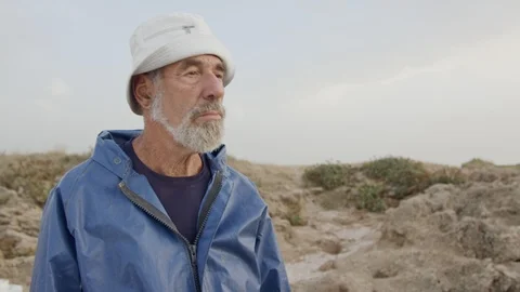 Old fisherman looking into the ocean using his binoculars Stock Footage 97273536