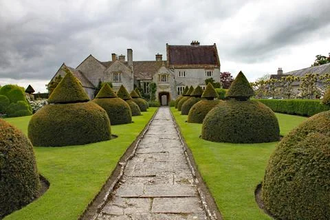 An old flag stone path leads up to an English country house. The path is bord Stock Photos